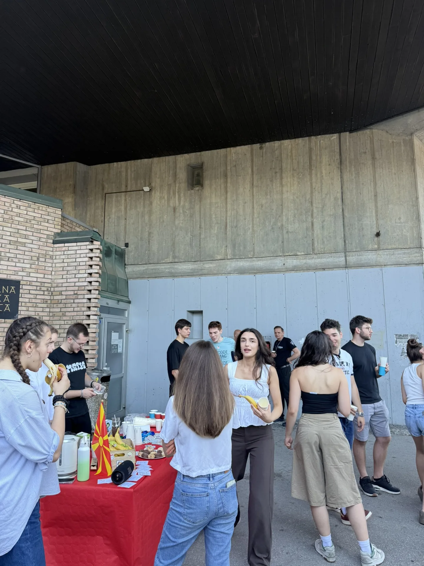 Спонтана фотографија од студенти кои разговараат покрај поставката.