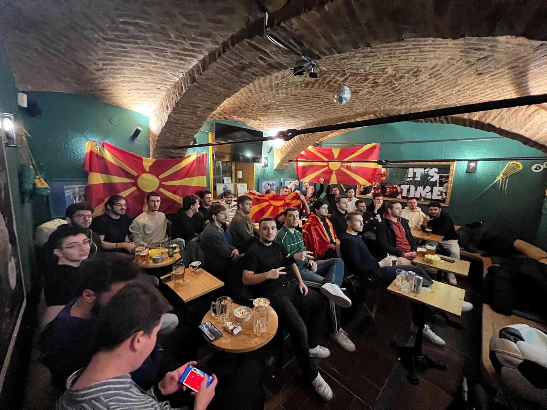 Študenti skupaj spremljajo nogometno tekmo med Makedonijo in Walesom v Lepi Žogi